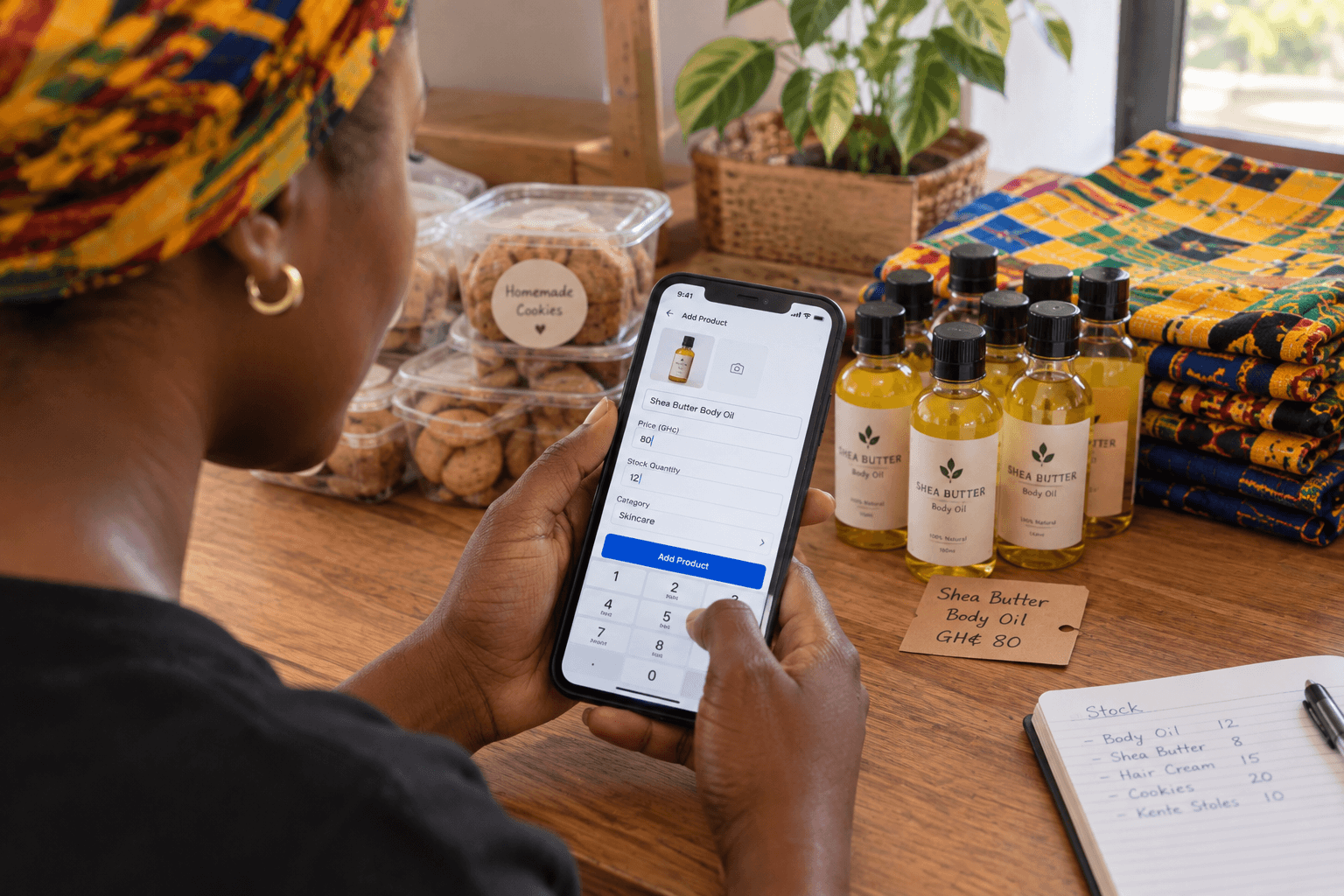 A merchant adding a shea butter body oil to her store on her phone, with a price in cedis and a stock count